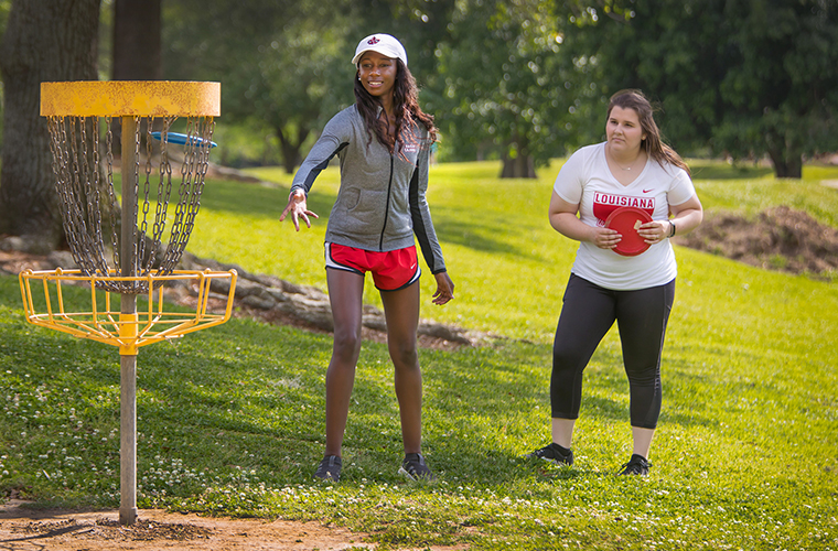 Two University of Louisiana at 69ý students playing frisbee golf in Girard Park