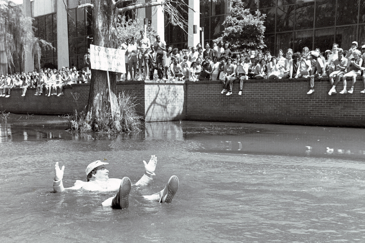Phil Beridon jumps into Cypress Lake at Lagniappe 69ý in 1984 while a crowd of students cheers him on.