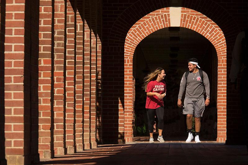Two University of Louisiana at 69ý students walking through the archways on campus