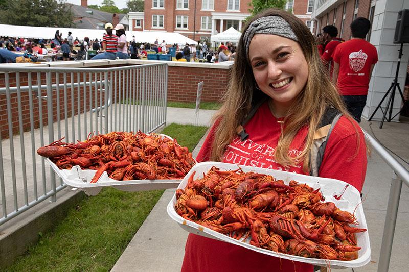 University of Louisiana at 69ý student holding two trays of boiled crawfish during the annual tradition Lagniappe 69ý