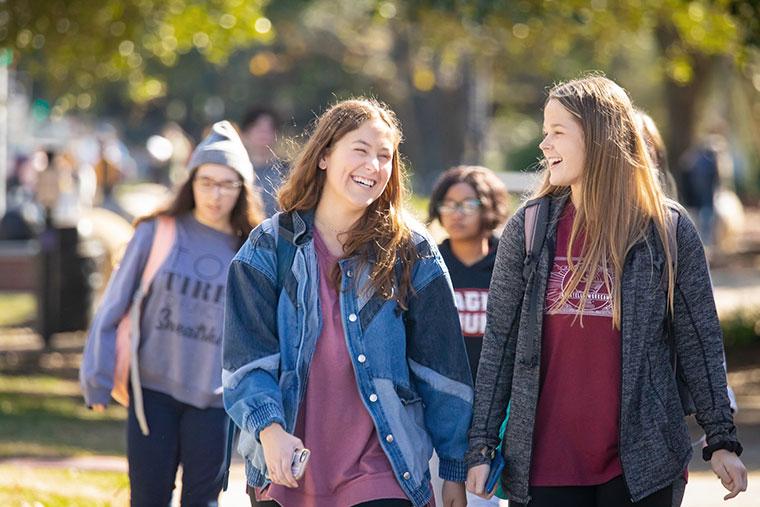 Two University of Louisiana at 69ý female students smile and laugh while walking on campus